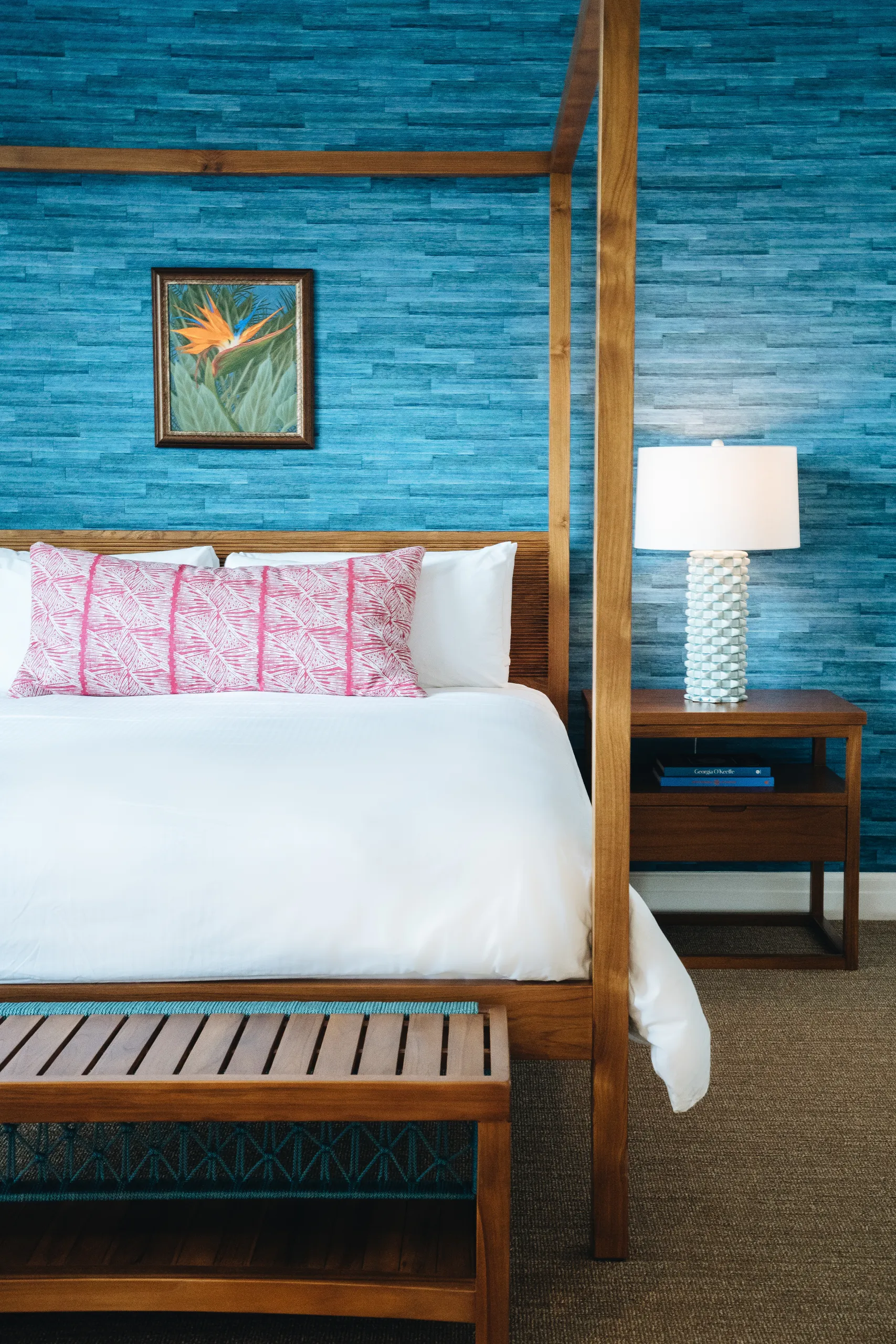 Clean bed with white sheets in a room with turquoise walls