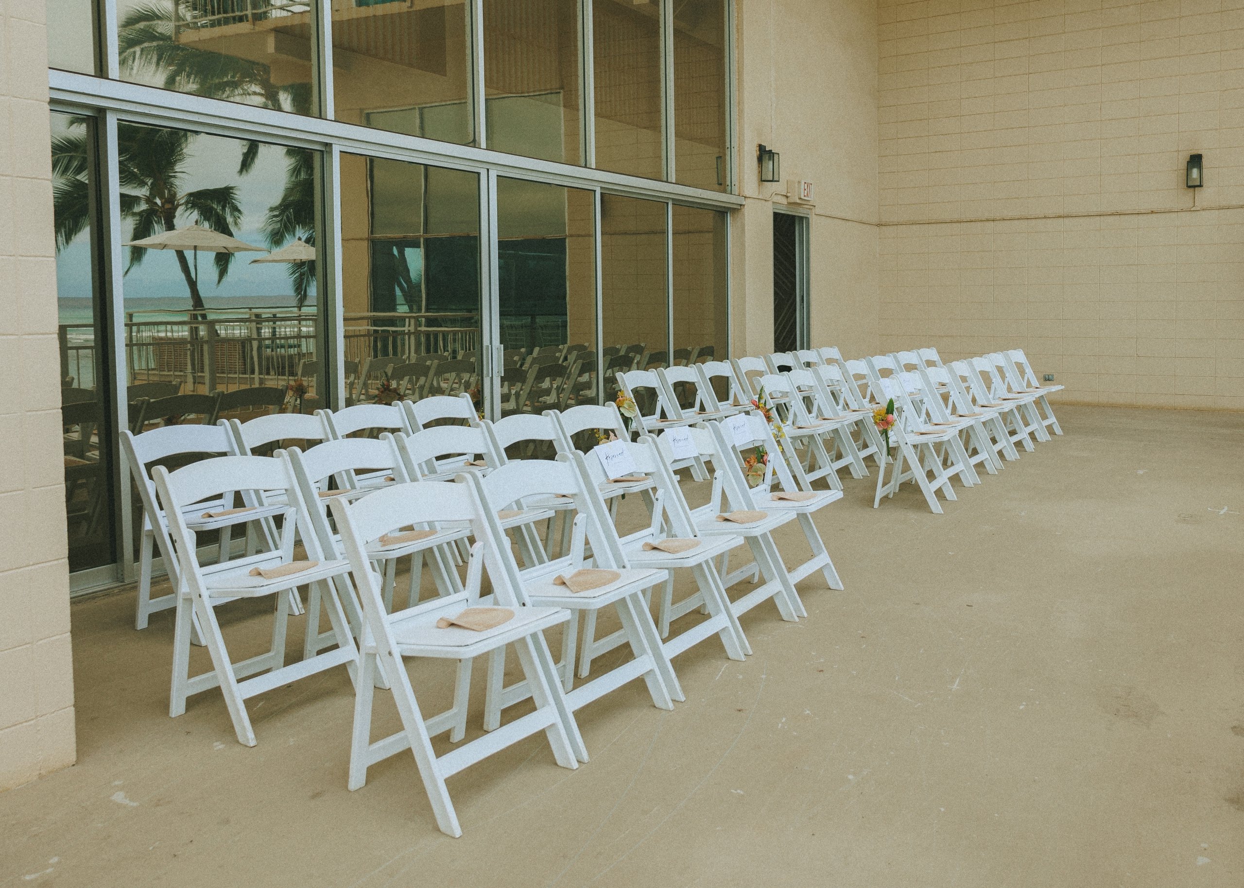 White chairs aligned in neat rows for wedding guests