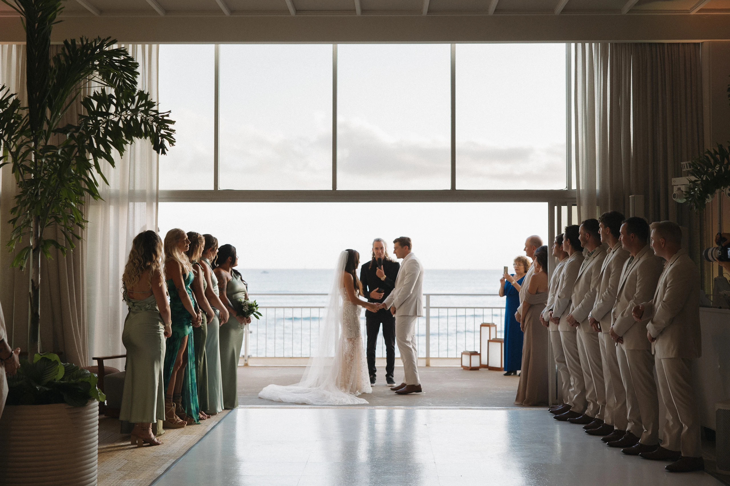 Bride and groom hold hands as they face each other during their wedding ceremony